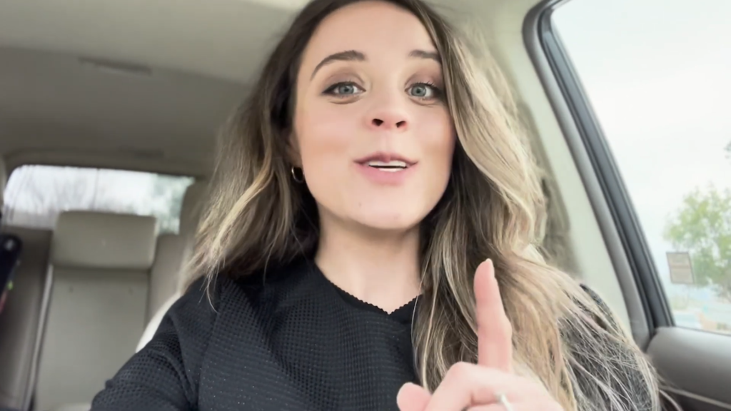 Jinger Duggar sits in her car and speaks down into the camera.