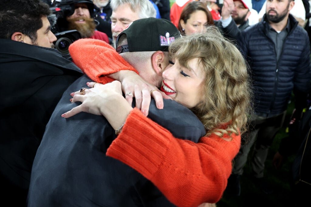 Taylor Swift and Travis Kelce embrace.