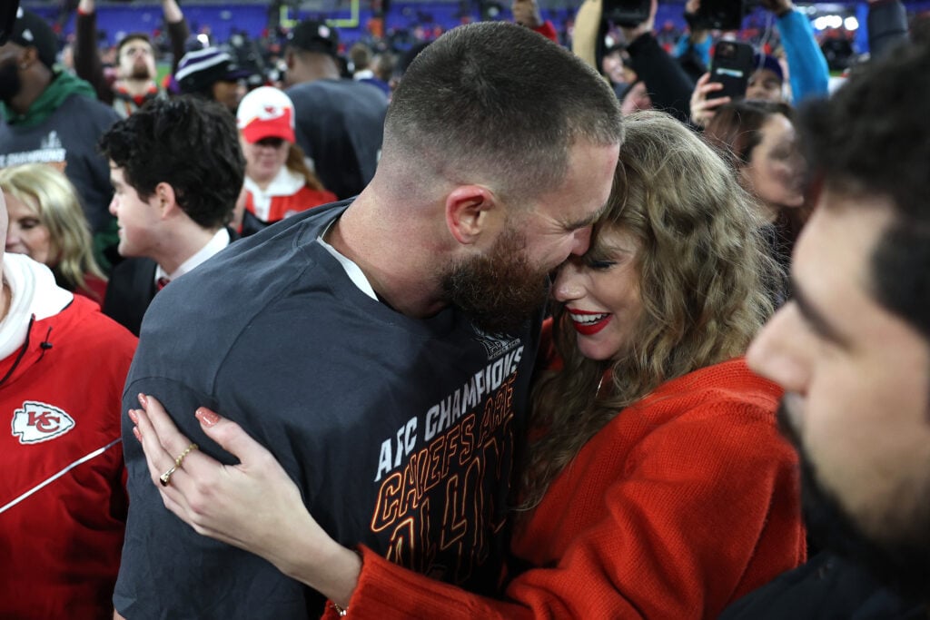 Travis Kelce on the field with Taylor Swift