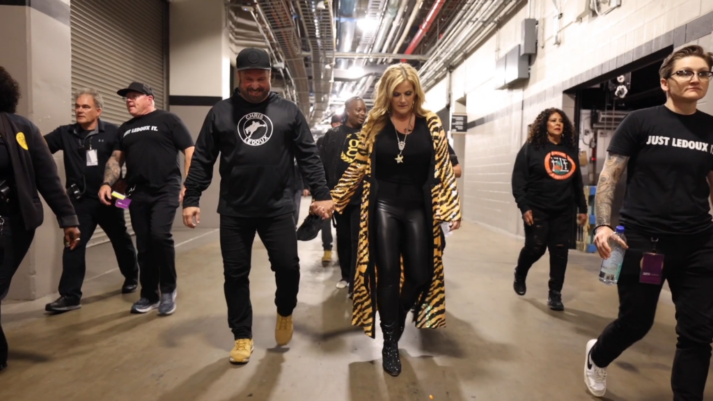 Garth Brooks and Trisha Yearwood hold hands.