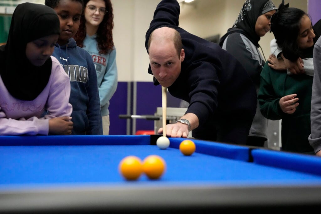 Prince William, Prince Of Wales plays a game of pool  during his visit to WEST, a new OnSide Youth Zone WEST on March 14, 2024 in London, England.