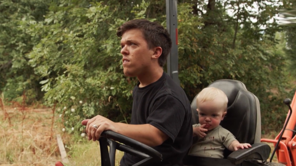 Zach Roloff and Josiah Roloff with a tractor outdoors.