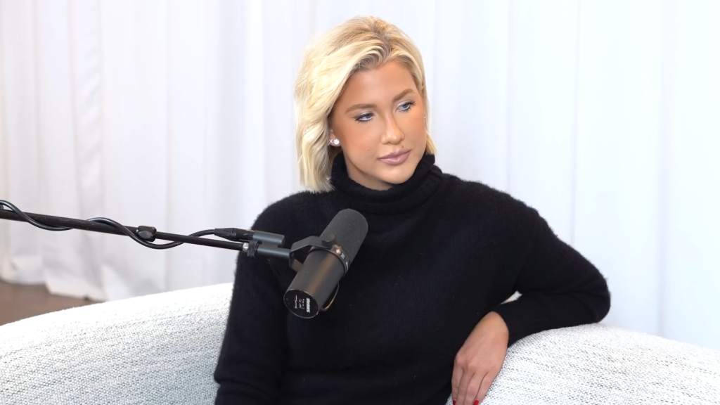 Savannah Chrisley wears black in an all-white podcasting room.